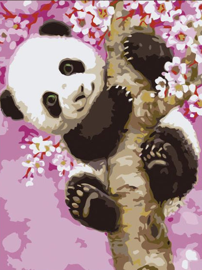 Framed artwork of a panda bear with cherry blossoms on a pink background, placed on a wooden surface.