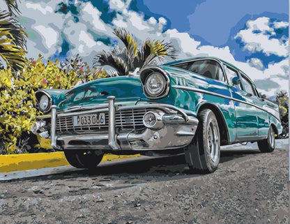 Vintage turquoise car on a road with palm trees and blue sky
